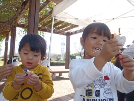 うれしそうに出来上がったストラップを見せる子ども