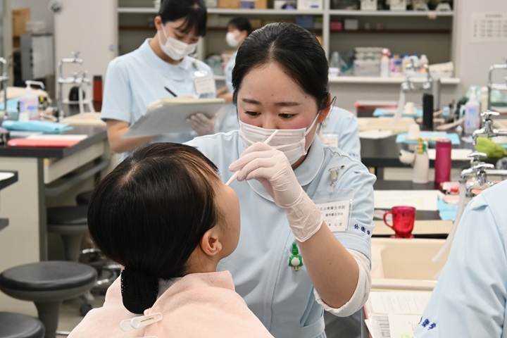先輩から保健指導を受ける1年生