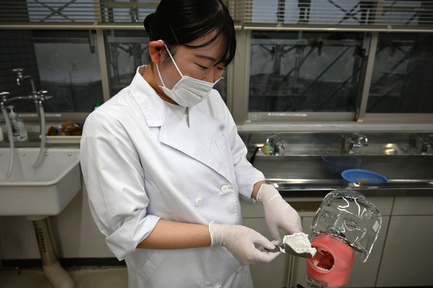 歯型の仕上がりを確認する学生
