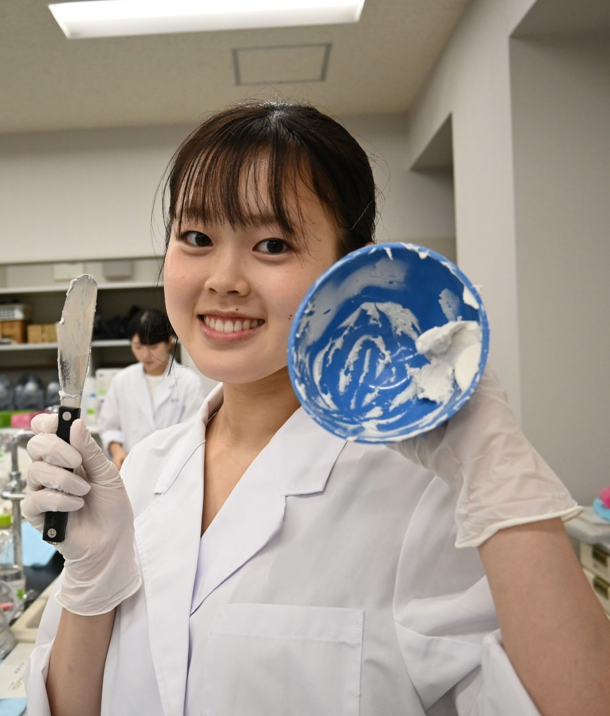 実習材料を笑顔で見せる学生