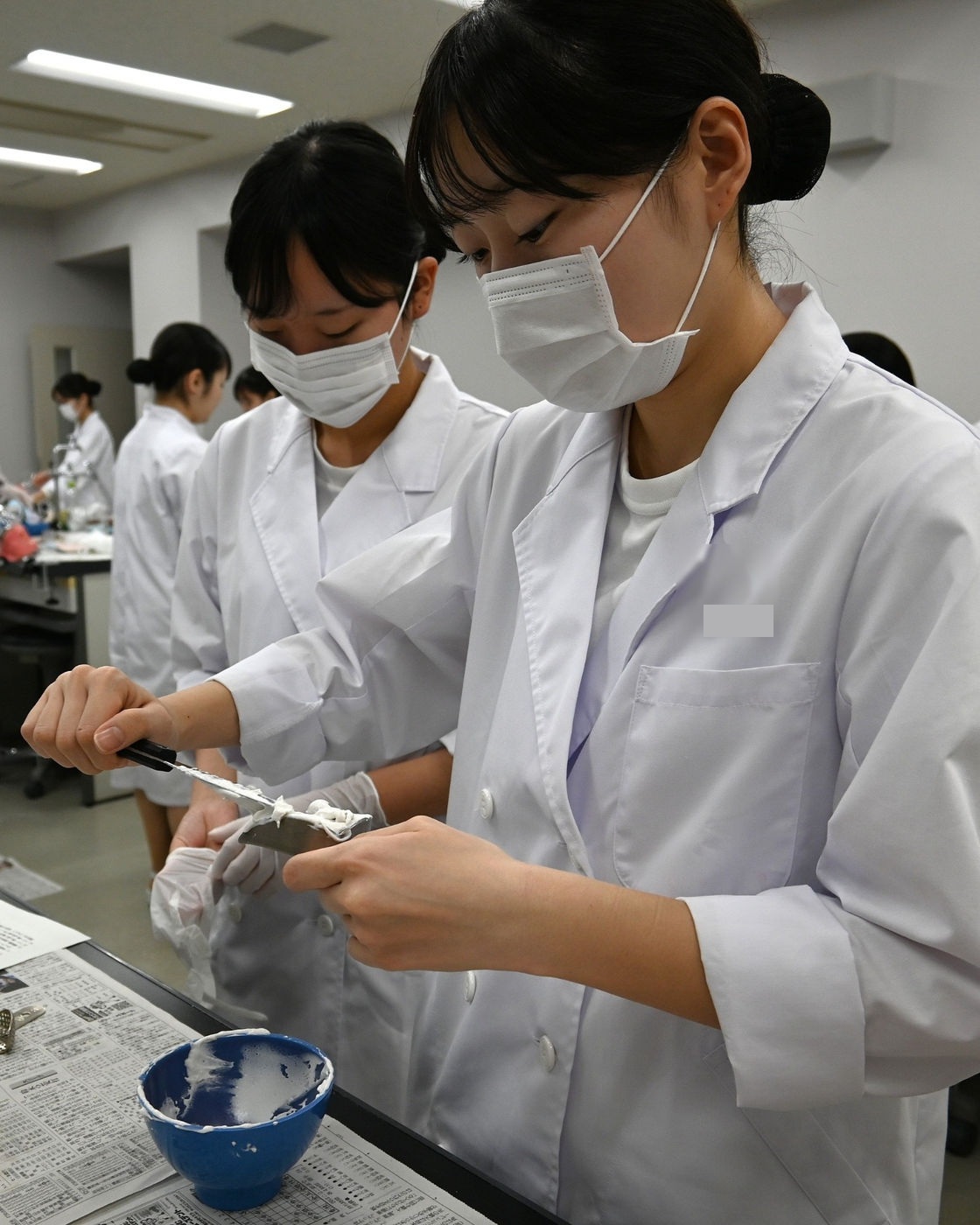 印象材をトレーに盛り付ける学生